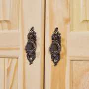 Detailansicht der beiden ornamental verzierten Griffe aus Metall am Kleiderschrank Dielenschrank Genf.