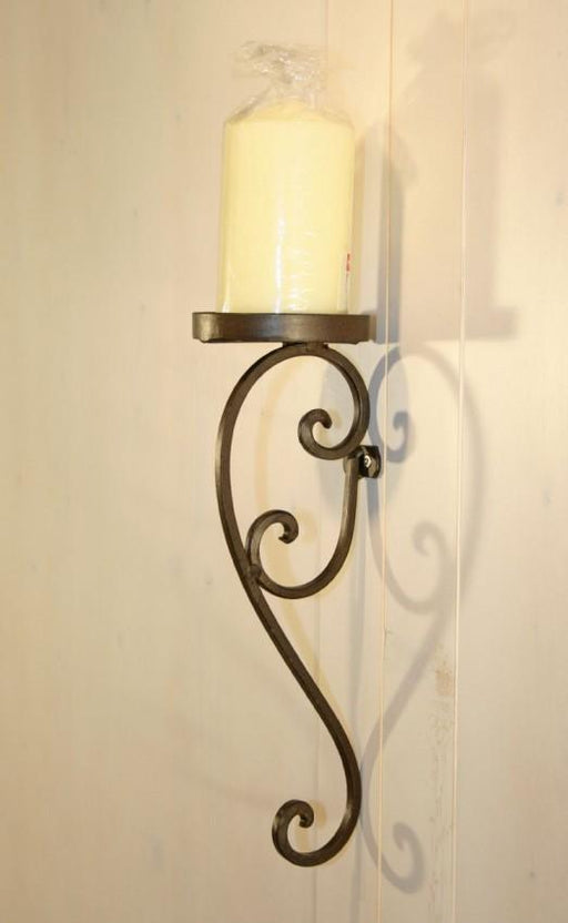 Wandkerzenhalter MASCALI aus Eisen in Antikbraun mit geschwungener Form an der Wand montiert, von vorne.