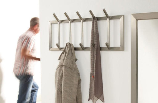 Wandgarderobe IMMO 5 mit fünf Haken in Edelstahl, an denen Textilien hängen, Gesamtansicht.