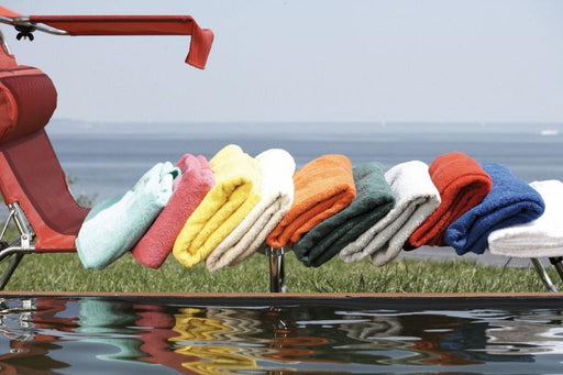 Frottier Auflage 190 x 70 cm für Amigo Liegen in verschiedenen Farben, auf einer roten Liege über Wasser arrangiert.