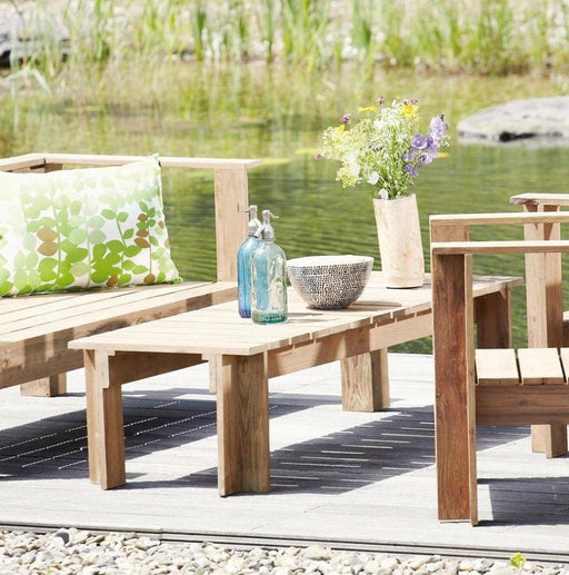 Gartentisch Teak Tisch BATTEN Jan Kurtz aus hellem Holz, Gesamtansicht auf Terrasse am Wasser.