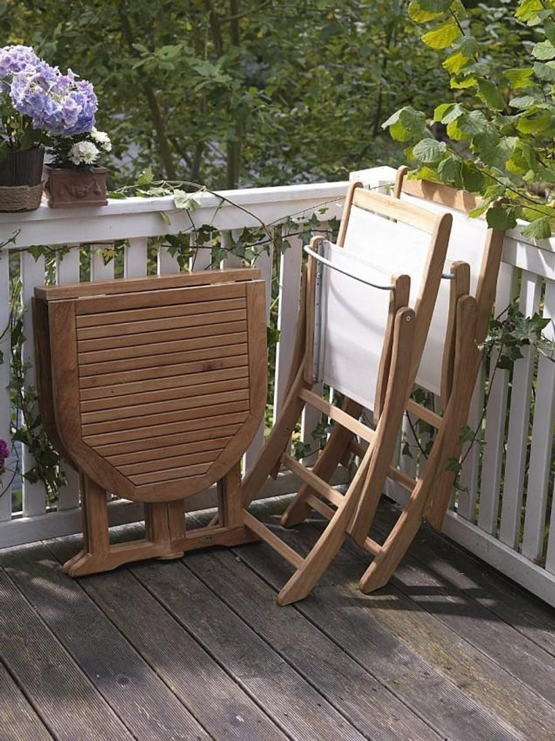 Balkontisch Klapptisch aus Teak 120 x 65 cm in Natur mit eingeklappter Tischplatte, daneben zwei Liegestühle.