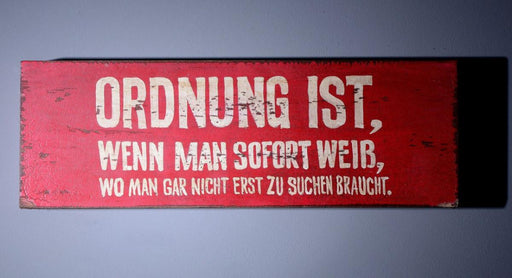 Wall Art Deko Holzschild „Ordnung ist ..." im Vintage Look mit rotem Grund und weißem Schriftzug, Gesamtansicht.