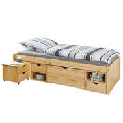 Funktionsbett Claas 90 x 200 aus Kiefer massiv mit gestreifter Bettwäsche, Kissen und integriertem Stauraum in Gesamtansicht.