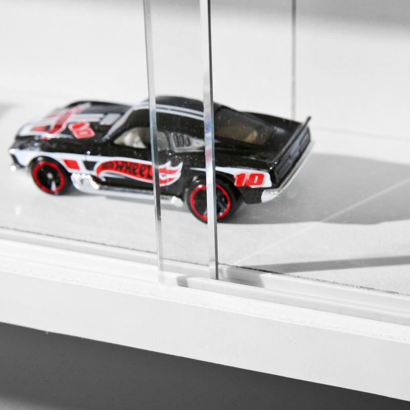 Sammlervitrine COMPILATI Weiß mit Glasschiebetüren, Seitenansicht mit ausgestelltem Spielzeugauto hinter Glas.