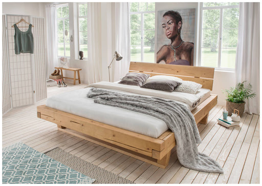 Bett Balkenbett UNIKA aus Fichte in Gesamtansicht mit massivem Holzgestell und geölter Oberfläche im hellen Schlafzimmer.