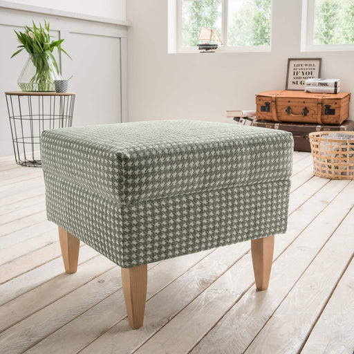 Hocker für Ohrensessel AVERSA in Olivgrün mit Hahnentrittmuster, Gesamtansicht von vorne mit Holzbeinen.