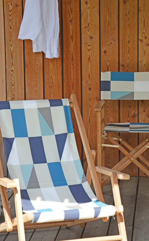 Liegestuhl Deckchair MAXX Bezug KARO Teakholz massiv Jan Kurtz in Gesamtansicht mit blauem Karomuster auf Holzterrasse.