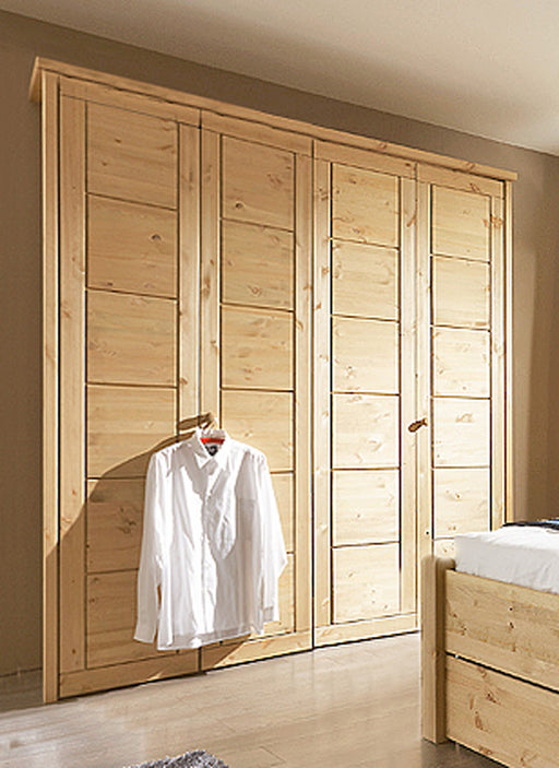 Kleiderschrank VITA SK279 mit vier Türen und Kassetten-Front aus Kiefer massiv, eine Tür teils offen mit weißem Hemd.