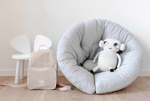 Sessel MINI NIDO Gesamtansicht mit grauem Bezug und weißem Kuscheltier in der Sitzfläche.