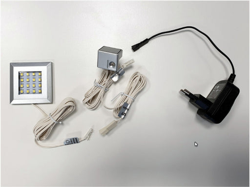 LED-Unterbaubeleuchtung Squere WW90 mit quadratischem LED-Modul, Stromkabel, Dimmer und Netzadapter in Gesamtansicht.