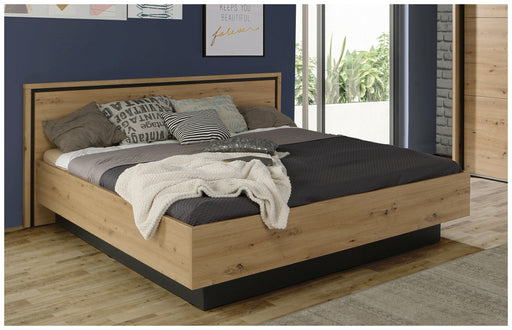 Doppelbett TRONDHEIM in Artisan Eiche mit schwarzem Sockel, Gesamtansicht von vorne mit bezogenem Bett und Kissen.