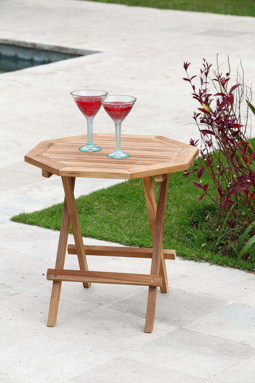 Beistelltisch Klapptisch LUANG achteckig aus Teakholz in Naturfarbe von vorne, auf einer Terrasse aufgestellt.