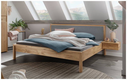 Massivholzbett AAGE 4 Wildeiche geölt mit grauer Filzplatte im Kopfteil, Gesamtansicht im Schlafzimmer.