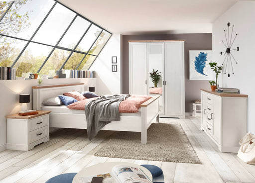 Schlafzimmer JASMIN mit weißem Bett, dreitüriger Schrank und Nachttisch in Gesamtansicht.