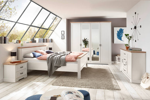 Schlafzimmer JASMIN mit Doppelbett, viertüriger Kleiderschrank und Kommode in Pinie-weiß in Gesamtansicht.
