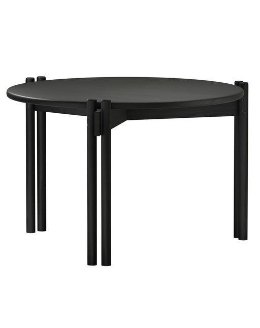 Gesamtansicht des Couchtisch STICKS HIGH mit ovaler schwarzer Tischplatte und vier zylindrischen Beinen aus Kiefer massiv.