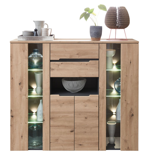Highboard MEMPHIS Artisan Eiche Graphit mit beleuchteten Seitenvitrinnen und zentralem Schubkasten in Gesamtansicht.