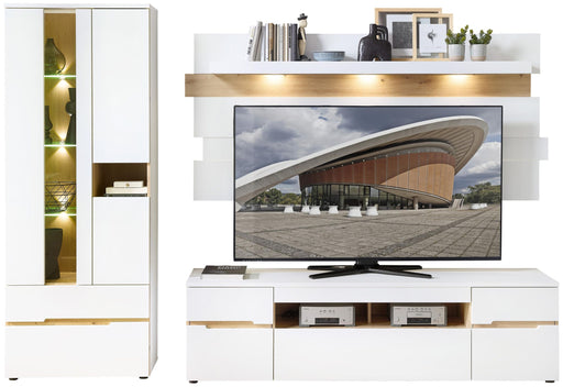 Wohnwand MEMPHIS in Weiß mit Artisan Eiche, Gesamtansicht mit TV-Lowboard, Wandregal und beleuchteter Vitrine.