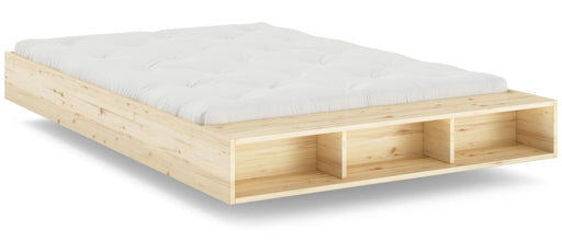 MERGE BED Kiefer natur Massivholzbett mit weißer Matratze und frontseitigem Stauraum in Gesamtansicht.