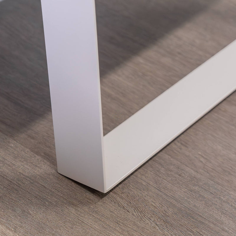 Nahaufnahme eines weißen Metalltischbeins auf einem Holzboden