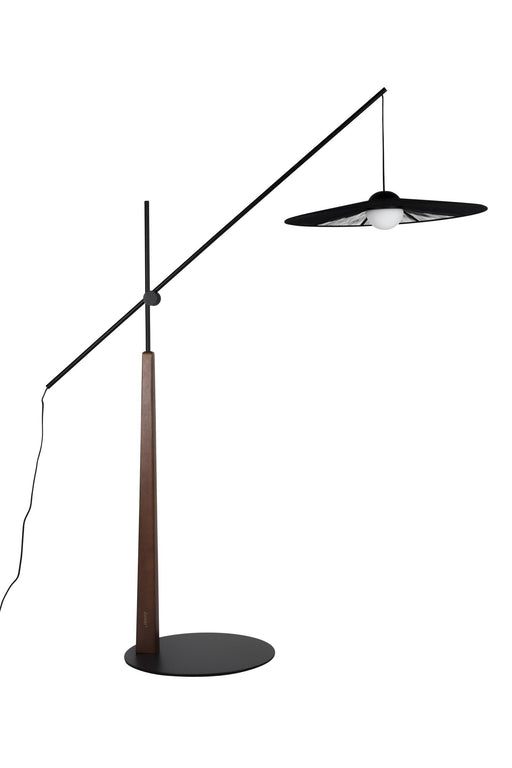 Design Stehlampe Belle Schwarz mit geschwungener Metallkonstruktion, Holzstamm und schwenkbarem Schirm in Gesamtansicht.