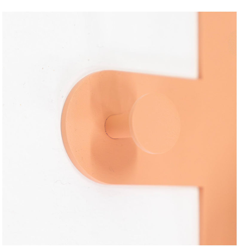 Nahaufnahme eines orangefarbenen Wandhakens in Form des Buchstabens C