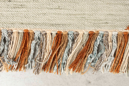 Detailaufnahme der Fransen des Teppich Saigon 160x230 in Orange mit gewebtem Muster aus recyceltem Polyester.