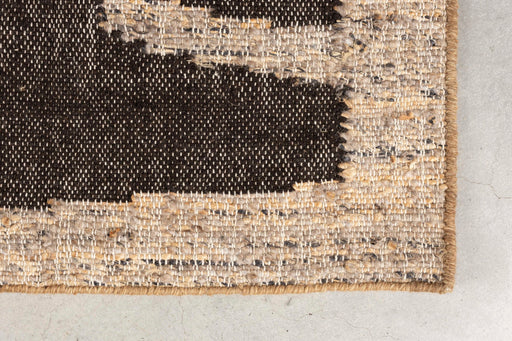 Teppich Briton 200x300 cm in Braun mit geometrischem Muster in Schwarz und Creme, Detailansicht der Webstruktur und Kante.