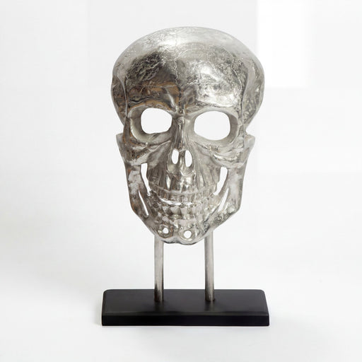 Standdeko Totenkopf Aluminium Silber 57 cm mit schwarzem Gestell in Vorderansicht auf schwarzem Sockel.