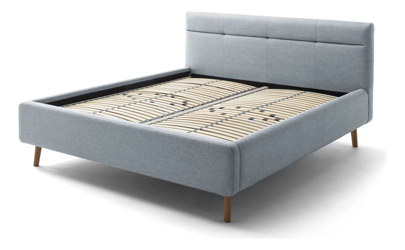 Polsterbett Lotte mit Bettkasten, gestepptem Kopfteil und Holzfüßen in Pastellblau – Ansicht 10
