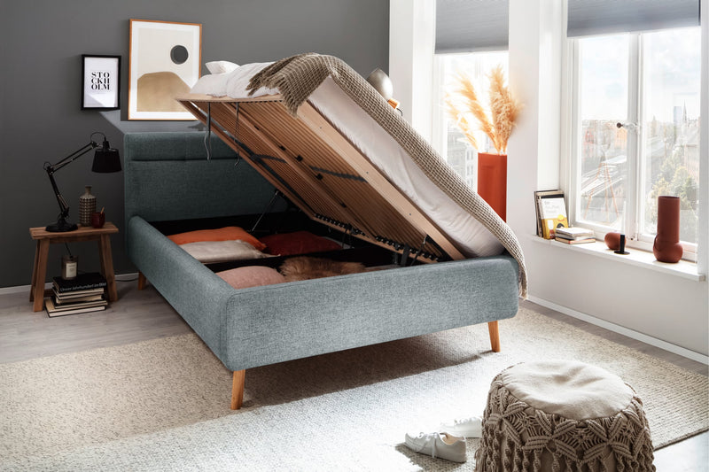 Polsterbett Lotte mit Bettkasten, gestepptem Kopfteil und Holzfüßen in Pastellblau – Ansicht 11