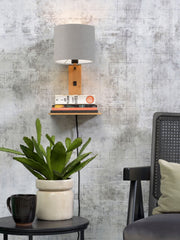 Good&Mojo Wandleuchte Andes Bambus mit hellgrauem Leinenschirm, an Wand mit Ablageboard und Büchern montiert.