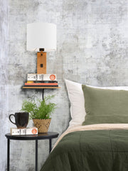 Wandleuchte Andes von Good&Mojo mit weißem Leinenschirm und Bambusgestell, mit Ablage und Büchern im Schlafzimmer.