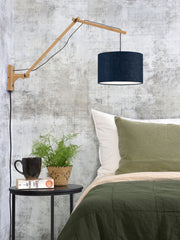 Wandleuchte Andes mit Bambusgestell und jeansblauem Leinenschirm, im Schlafzimmer neben dem Bett montiert.