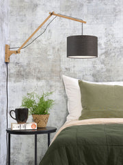 Wandleuchte Andes von Good&Mojo mit Bambusarm und dunkelgrauem Leinenschirm, über einem Bett montiert.