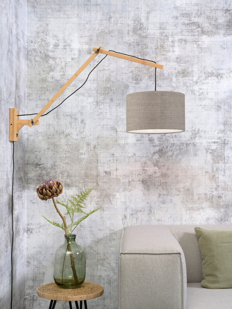 Gesamtansicht der Wandleuchte Good&Mojo Andes mit Bambusgestell und rundem Leinenschirm in Dunkelbeige, über einem Sofa.
