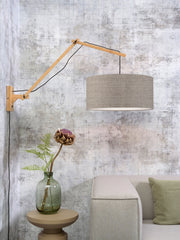 Good&Mojo Wandleuchte Andes mit Bambusarm und dunklem Leinenschirm, an einer strukturierten Wand im Wohnraum montiert.