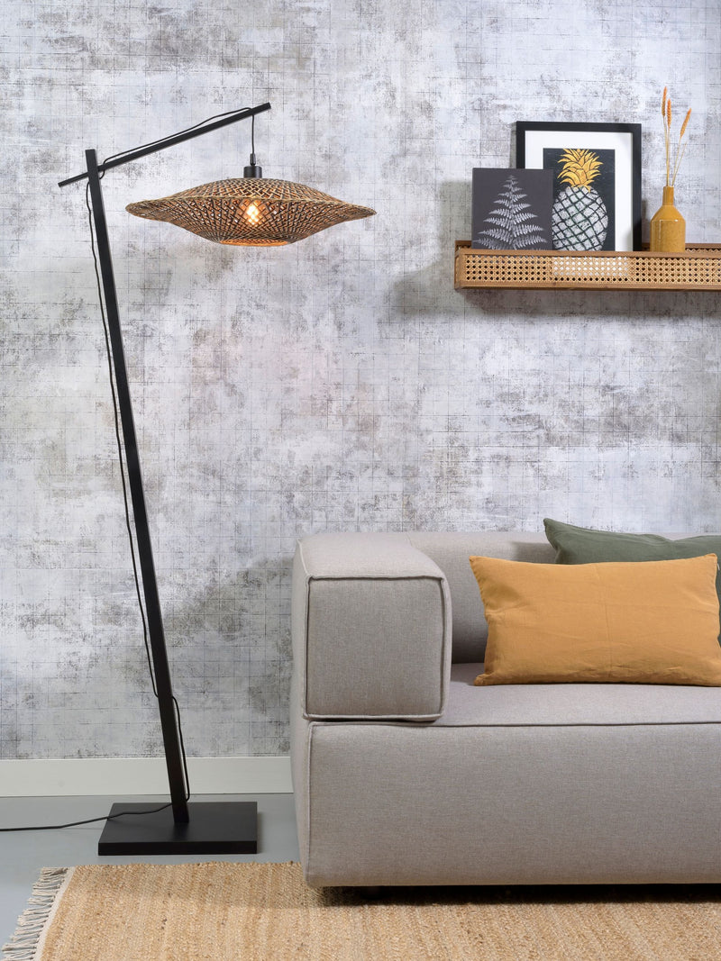Stehleuchte Bali von Good&Mojo mit geflochtenem Bambusschirm in Natur und schwarzem Gestell, im Wohnzimmer neben einem Sofa.