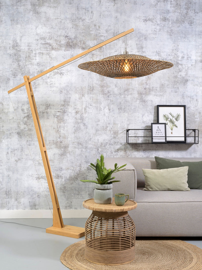 Stehleuchte Bali von Good&Mojo aus Bambus mit geflochtenem Naturschirm, schräg über einem Sofa im Wohnraum