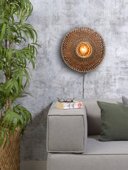 Wandleuchte Bali von Good&Mojo aus Bambus in Natur/Schwarz, an einer grauen Wand über einem Sofa montiert.