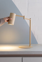It's about RoMi Tischleuchte Bilbao in Beige, mit schwenkbarem Arm, Hand justiert den Schirm.