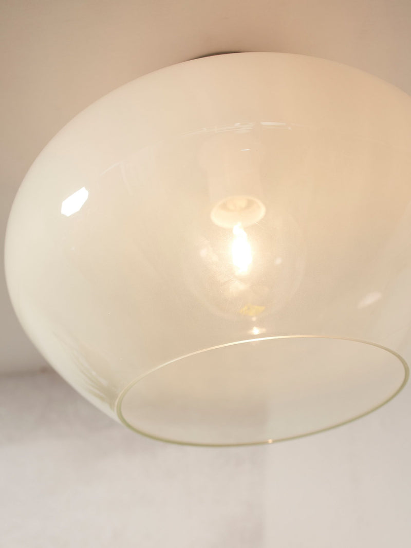 Detailansicht der RoMi Deckenleuchte Bologna aus milchweißem Glas mit sichtbarer Glühbirne im Inneren des Schirms.
