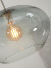 Detailansicht der Hängeleuchte It's about RoMi Bologna mit grauem Glasschirm und sichtbarem Glühlampen-Filament