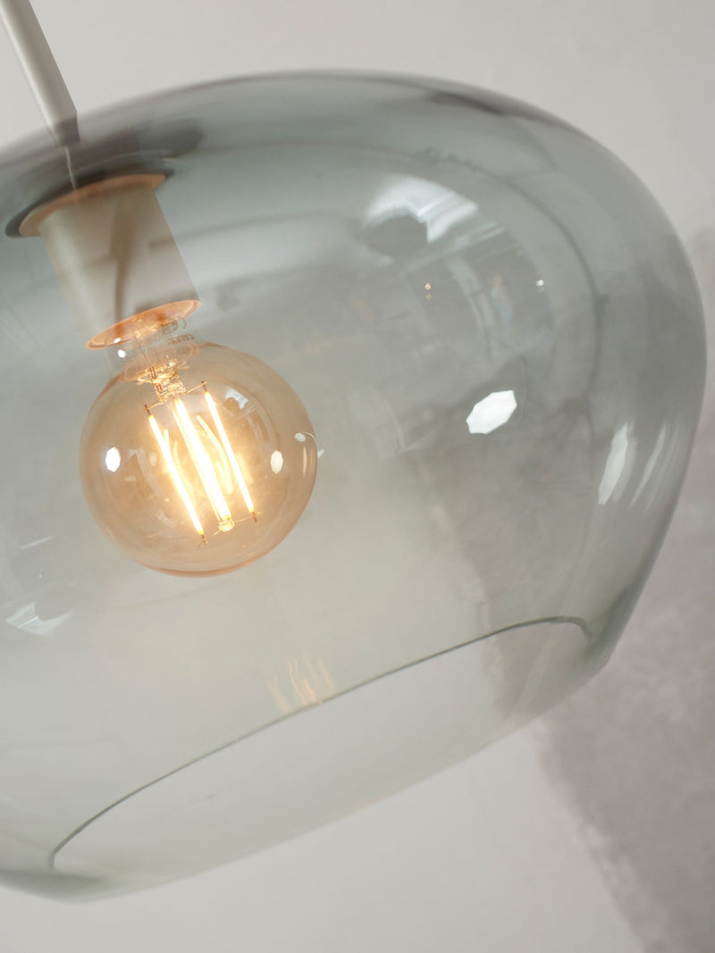 Detailansicht der Hängeleuchte It's about RoMi Bologna mit grauem Glasschirm und sichtbarem Glühlampen-Filament