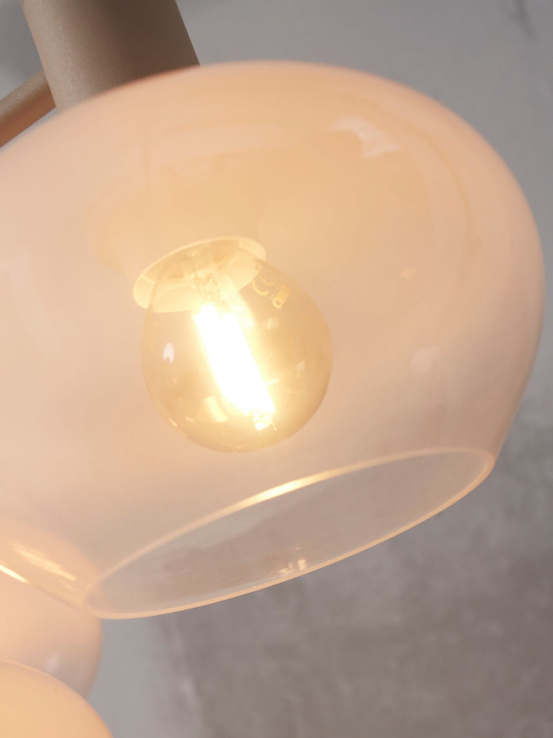 Detailansicht der Hängeleuchte It's about RoMi Bologna: milchweißer Glasschirm mit warm leuchtender Filament-Glühlampe.