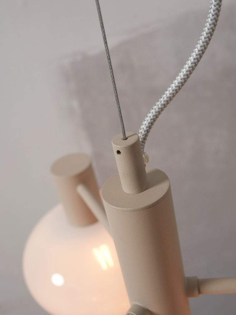 Detailansicht der Hängeleuchte It's about RoMi Bologna: beige Metallstreben, Stahlseil, geflochtenes Textilkabel und weißer Glasschirm.
