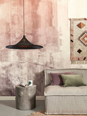 Hängeleuchte Borabora von Good&Mojo aus schwarzem Rattan über einem Sofa in einem Wohnraum mit rosa Wandgestaltung.