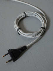 Textiles, weiß-graues Stromkabel mit Schutzkontaktstecker, zu einem Kreis aufgerollt und mit schwarzen Kabelbindern gesichert.