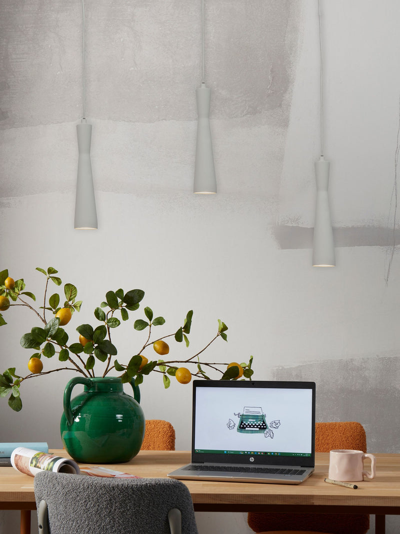 Hellgraue Hängeleuchten "It's about RoMi Bordeaux" aus Eisen hängen über einem Holztisch mit grüner Vase und Laptop.